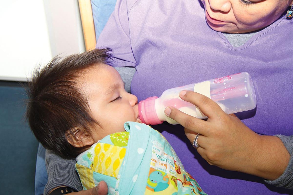 A student mother feeding her baby in one of SJC's lactation and family rooms